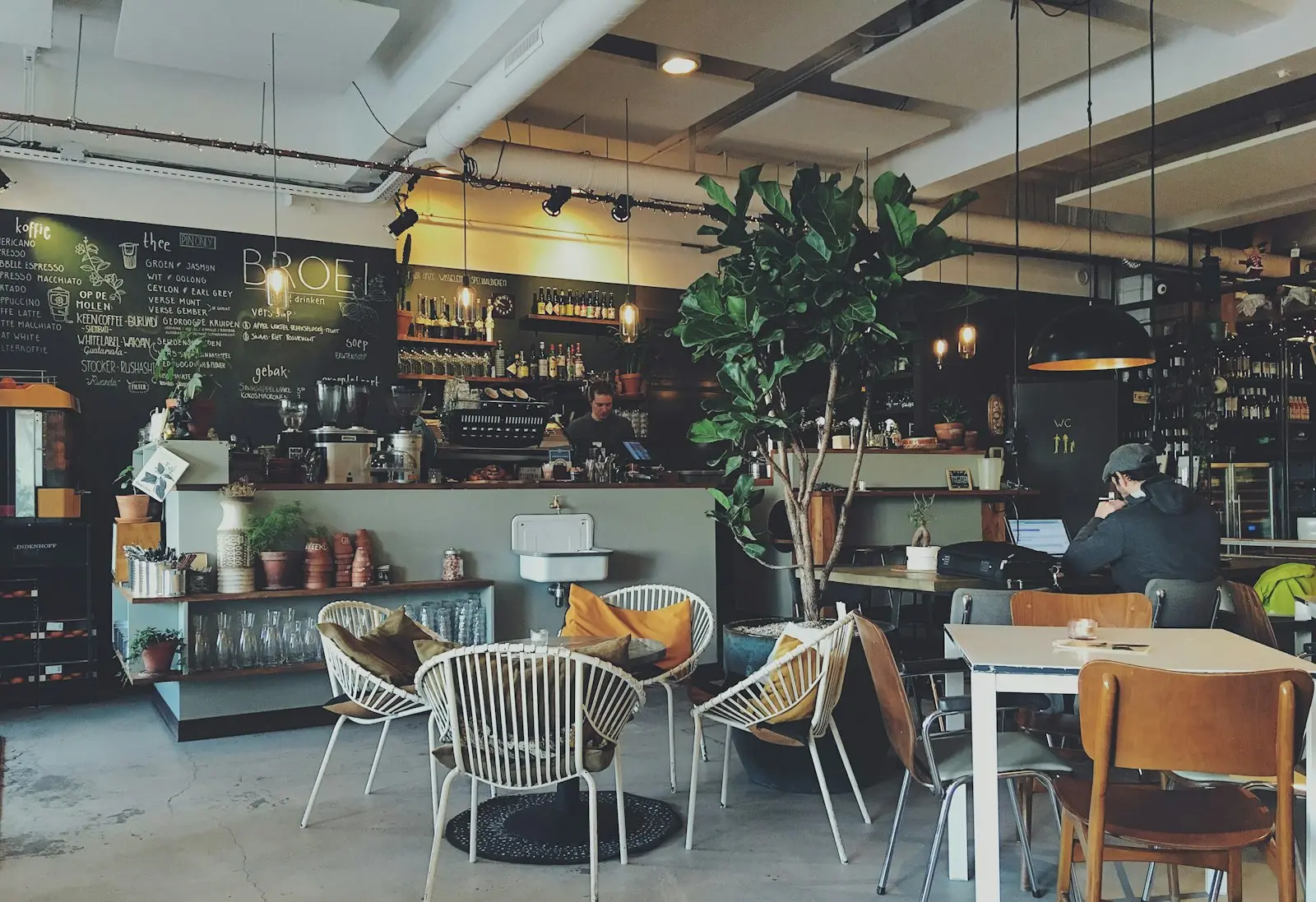 A warm, busy cafe interior with customers at the counter