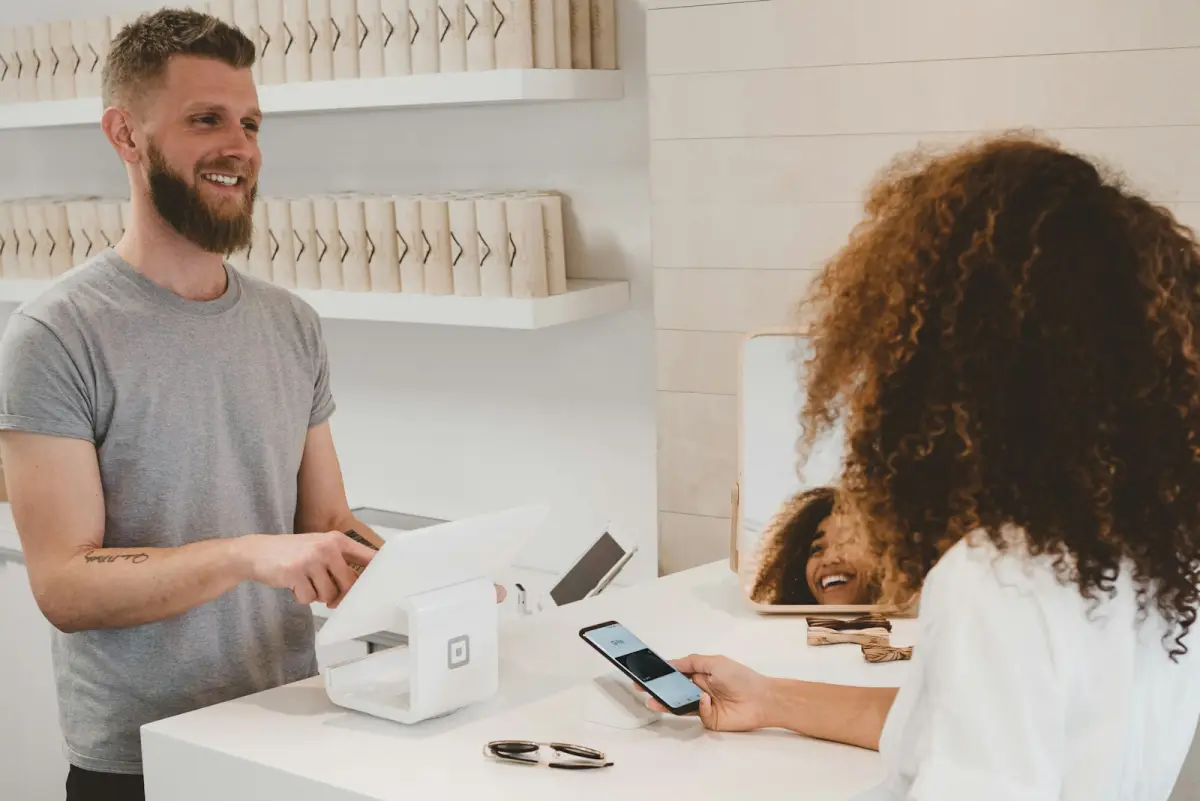A customer holding a phone at a shop counter